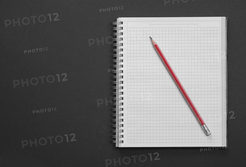 Clean square copybook with red pen on black background education concept