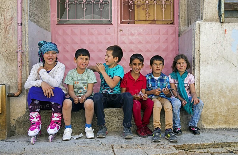 Turkish children sitting on doorstep of house in the city Erzurum