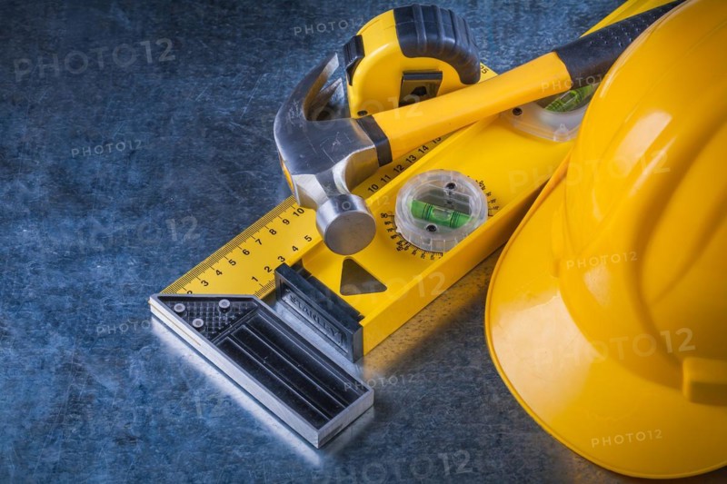 Measuring instruments Claw hammer and construction helmet on scratched metallic background Maintenance concept