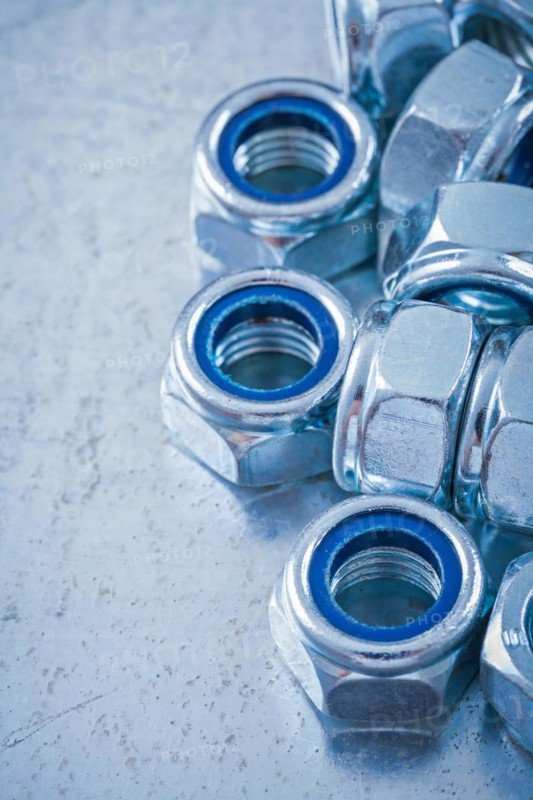Collection of steel nuts on flat metallic background Construction concept