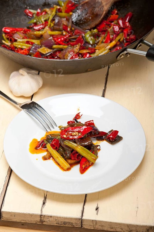 Fried chili pepper and vegetable on a iron wok pan
