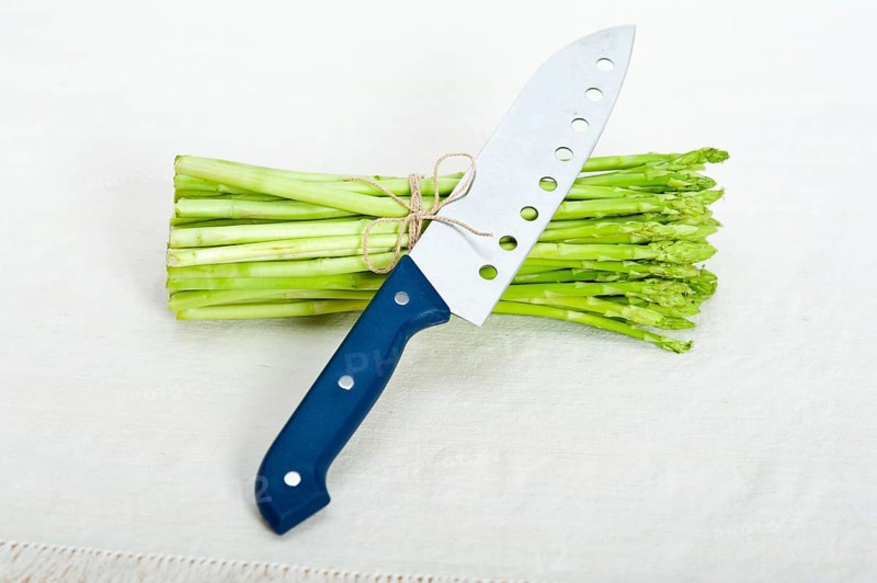 Fresh asparagus from the garden over white background with kitchen knife