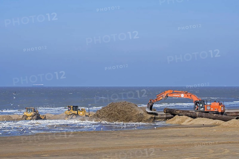 Bulldozers and hydraulic excavator installing pipeline during sand replenishment