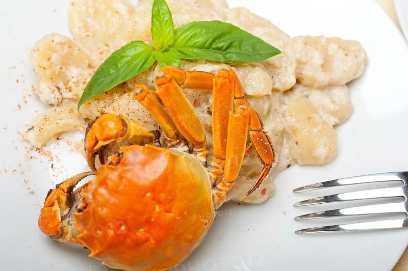 Fresh homemade Italian gnocchi with seafood sauce crab and basil