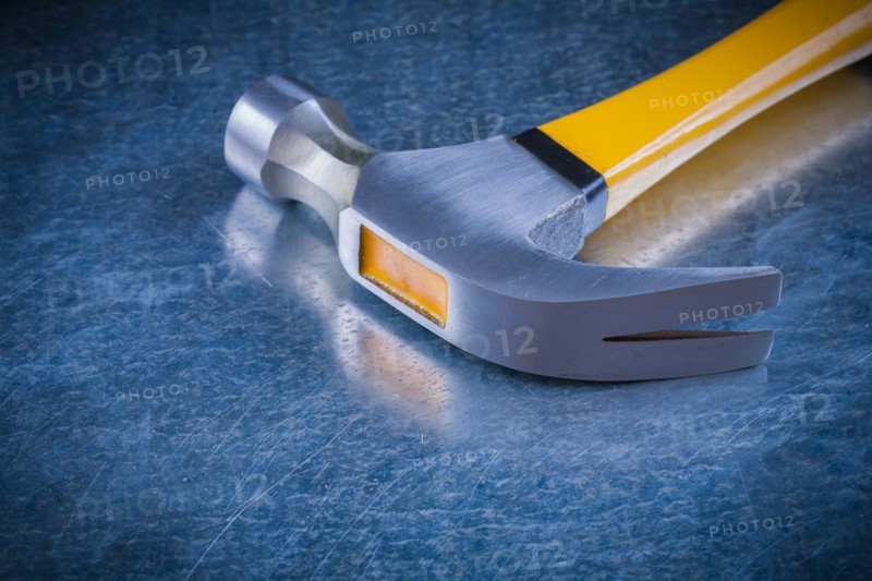 Claw hammer on scratched vintage metallic background construction concept