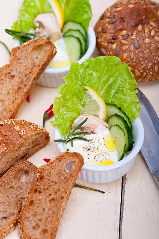 Fresh organic garlic cheese dip salad on a rustic table with bread