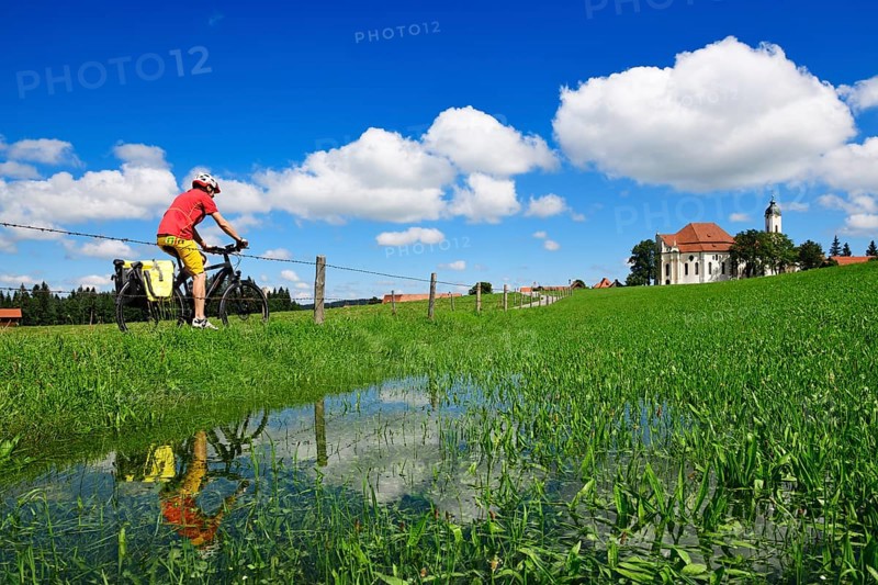 Cyclist with touring bike in front of the Wieskirche