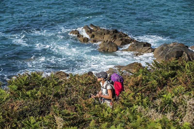 Elderly woman following the sentier des douaniers trail along the Brittany