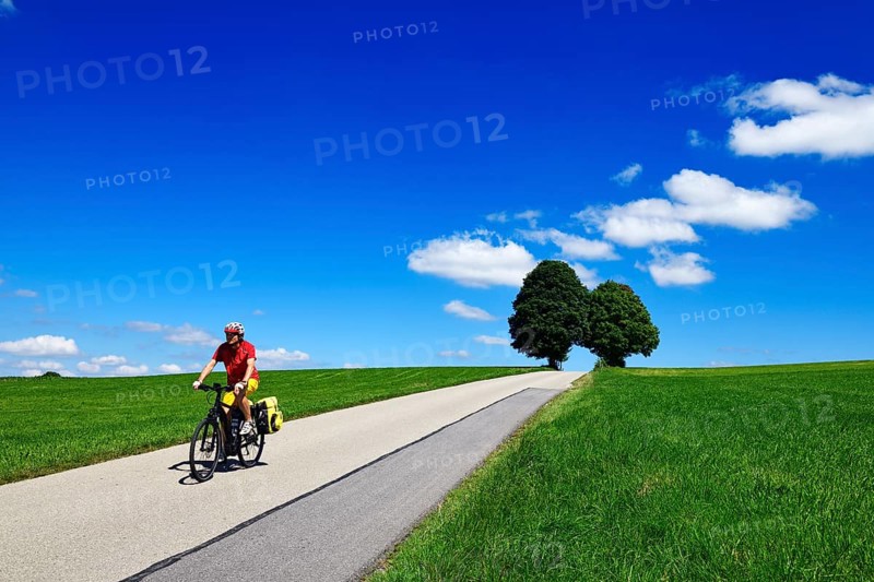 Cyclist on a picture-book country road near Berg