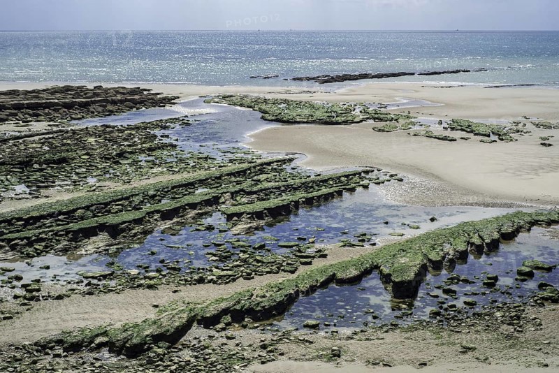 Jurassic rock layers exposed at low tide on the beach at Ambleteuse along rocky North Sea coast