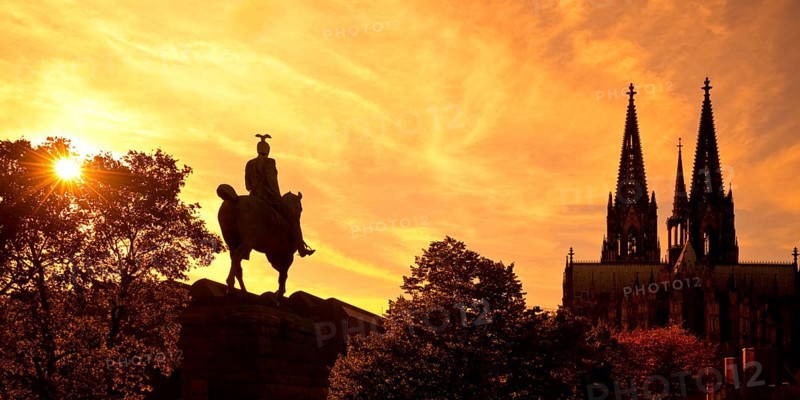 Equestrian statue of Kaiser Wilhelm II backlit with the silhouette of the cathedral