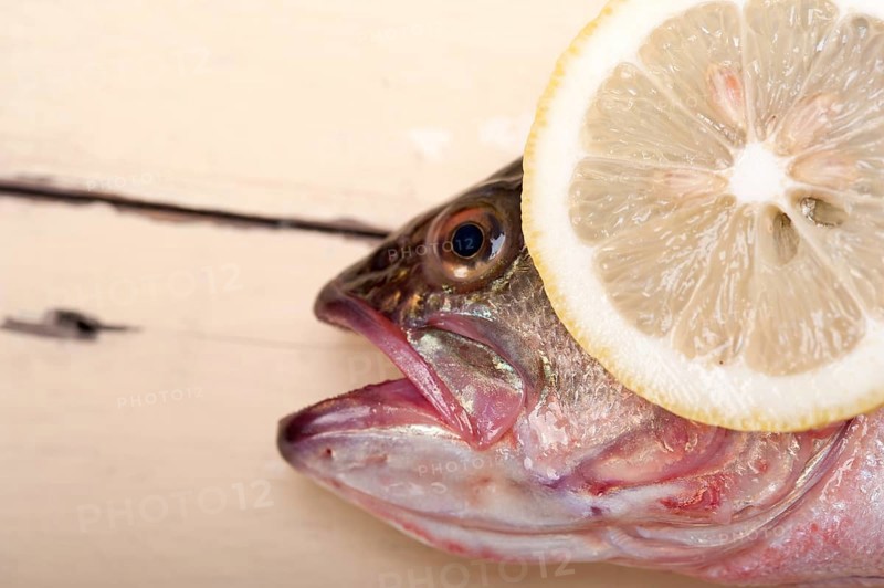 Fresh whole raw fish on a wooden table ready to cook
