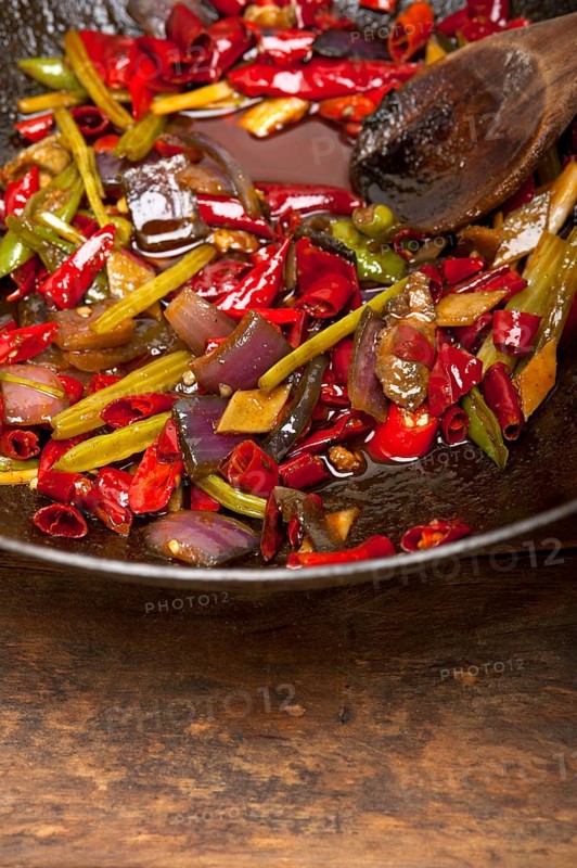 Fried chili pepper and vegetable on a iron wok pan