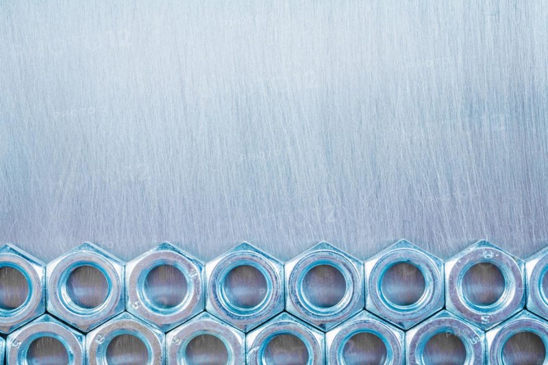 Copy Space image of stainless steel construction nuts on a metallic background Repair concept