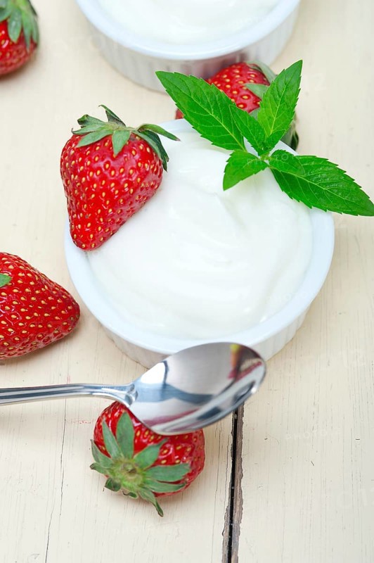 Organic Greek yogurt and strawberry over white rustic wood table