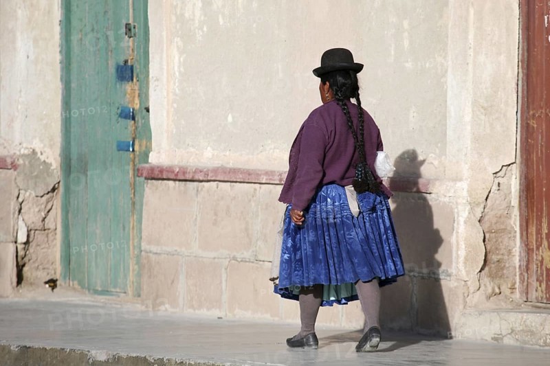 Woman in traditional dress wearing bowler hat and skirt at Uyuni