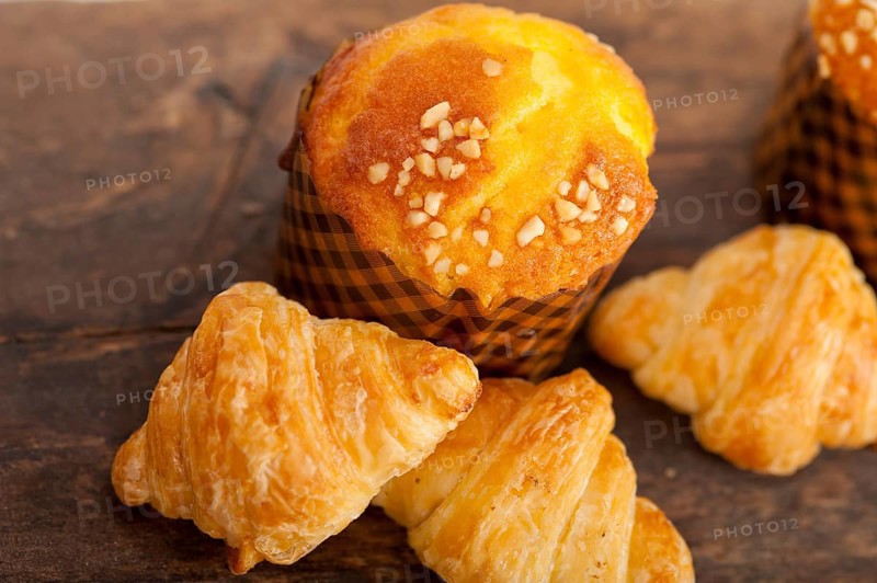 Fresh baked muffin and croissant mignon on old wood table