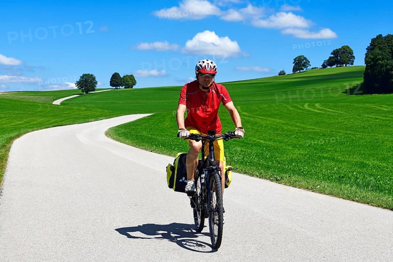 Cyclist on a picture-book country road near Berg
