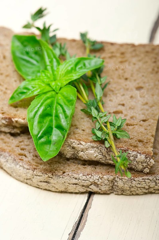 Rustic Italian bread basil and thyme simple snack on white wood table