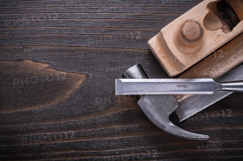 Copy space image of claw hammer razor plane and chisel on vintage wooden board building concept
