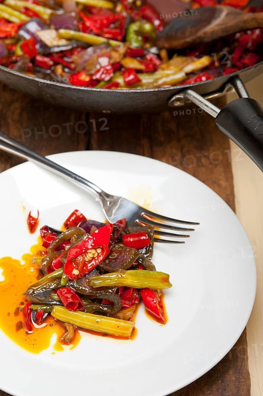 Fried chili pepper and vegetable on a iron wok pan