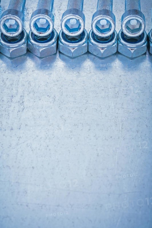Group of threaded nuts and bolts details on metallic background copy space image construction concept