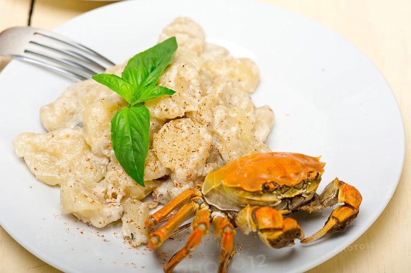 Fresh homemade Italian gnocchi with seafood sauce crab and basil