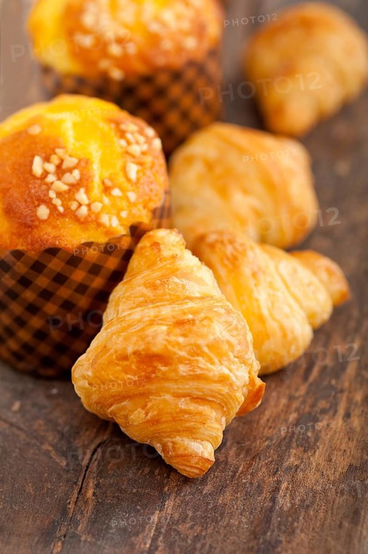 Fresh baked muffin and croissant mignon on old wood table
