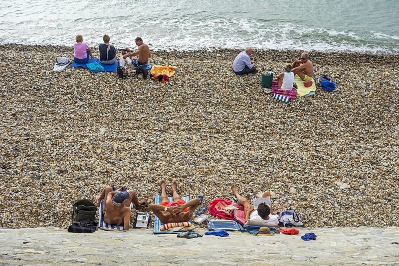 Sunbathers sunning on shingle beach along the North Sea coast
