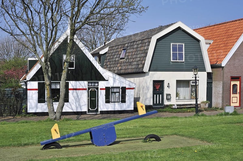 Seesaw and traditional houses in the village Oudeschild