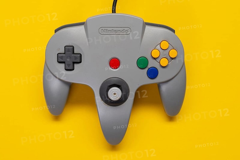 Controller Nintendo 64 game console in front of monochrome yellow background