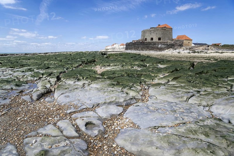 Jurassic rock layers exposed at low tide and Fort Mahon at Ambleteuse along rocky North Sea coast