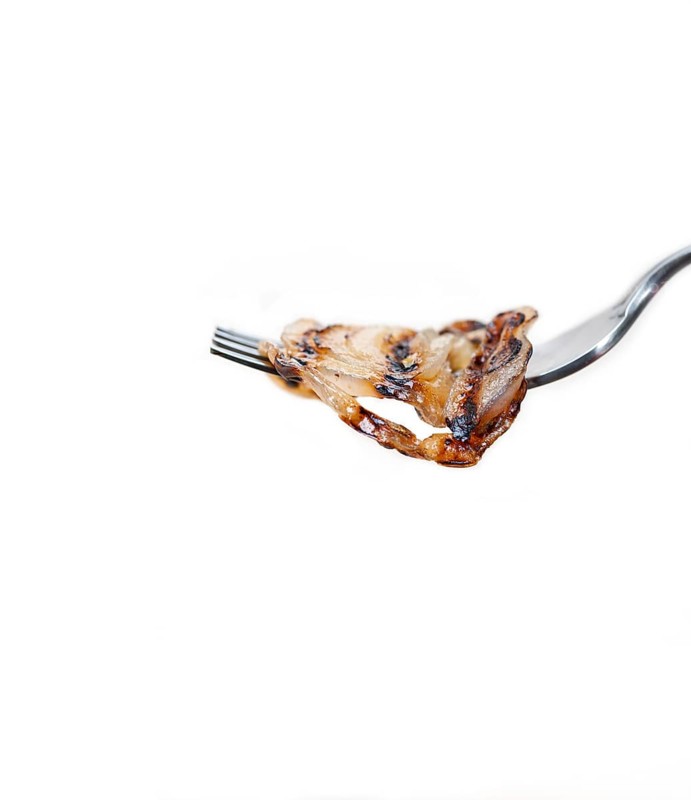 Grilled onion on a fork macro close up