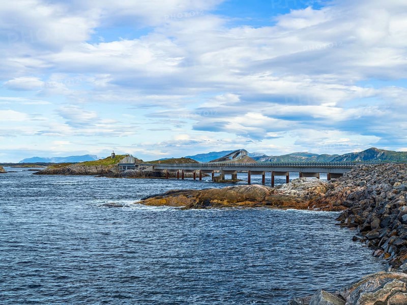 Bridge connecting rocky shores under a cloudy sky