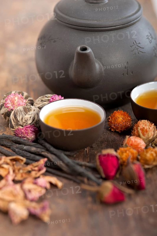 Chinese style herbal floral tea over wood table with raw ingredients