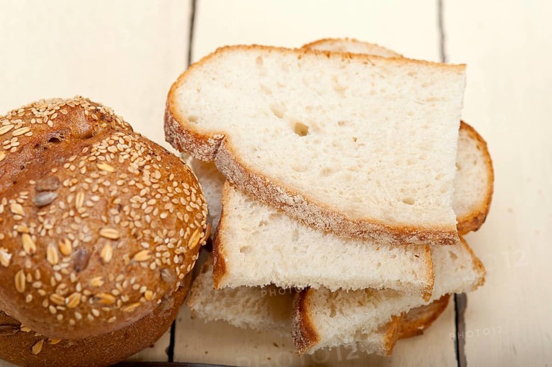 Fresh organic bread over rustic table macro closeup