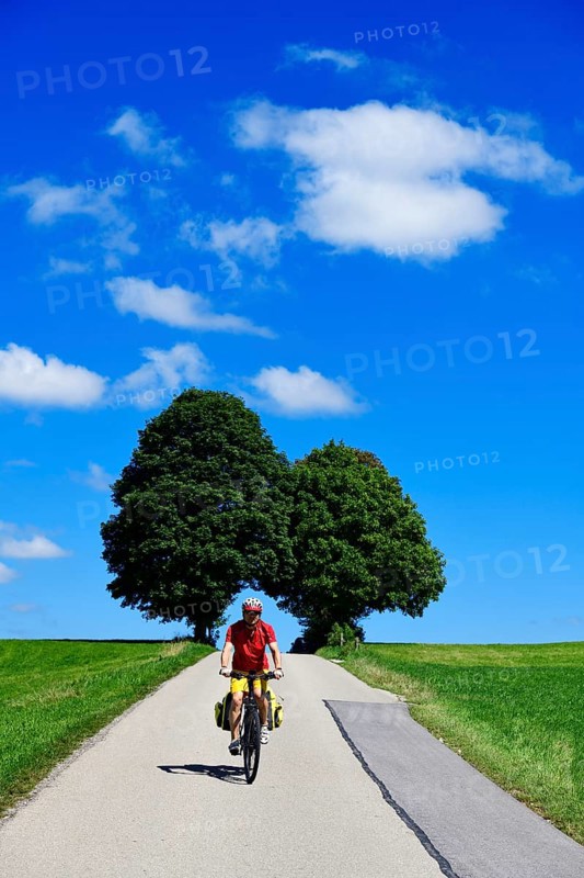Cyclist on a picture-book country road near Berg