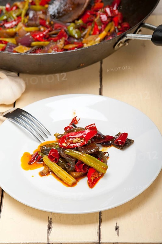 Fried chili pepper and vegetable on a iron wok pan