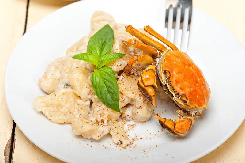 Fresh homemade Italian gnocchi with seafood sauce crab and basil
