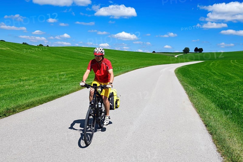 Cyclist on a picture-book country road near Berg
