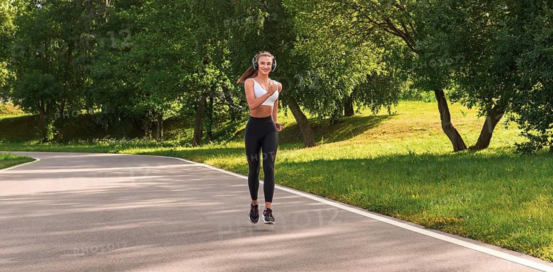 Fitness girl in sportswear runs through the evening sunny park. Healthy lifestyle. Mixed media