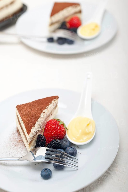 Classic Italian tiramisu dessert with berries and custartd pastry cream on side