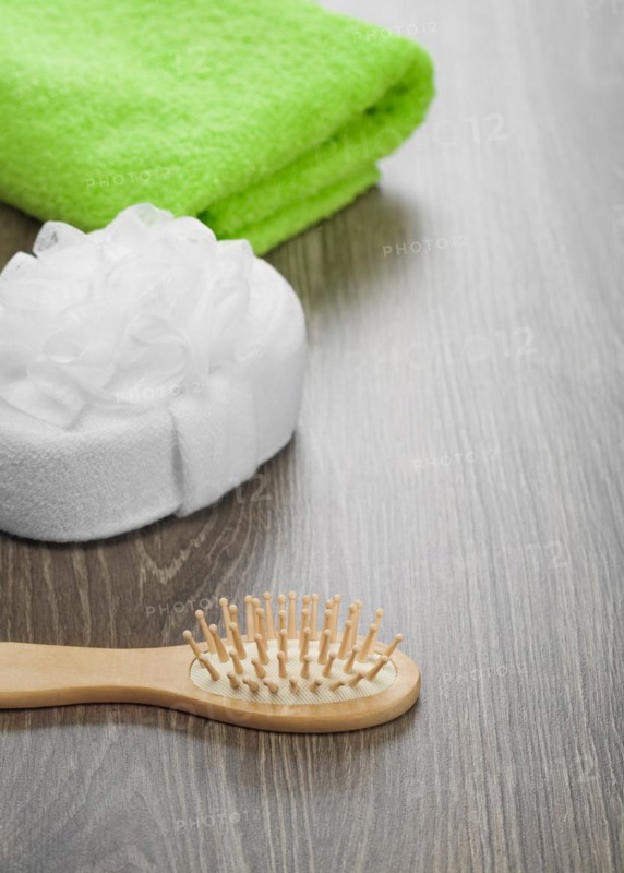 Hairbrush and bath sponge with green towel