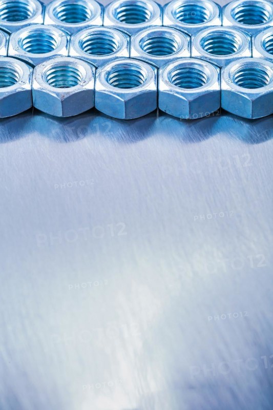 Copyspace image of metal screw nuts on a metallic background Design concept