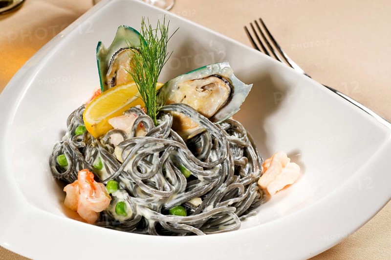 Fresh seafood black squid ink coulored spaghetti pasta tipycal italian food