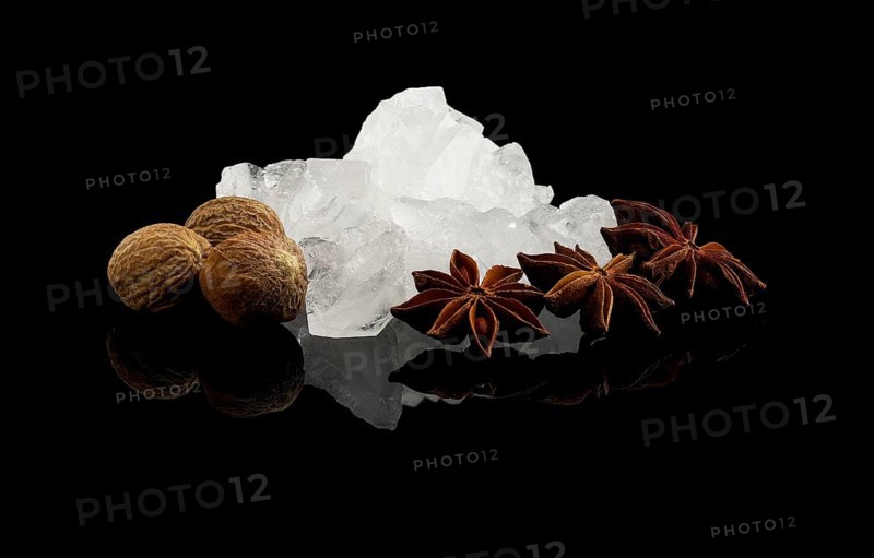 Crystal sugar and spice over black reflective surface background