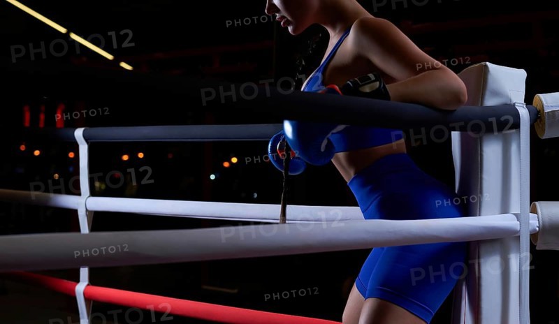 Noname photo of an athletic busty woman in a boxing ring. The concept of sports and mixed martial arts