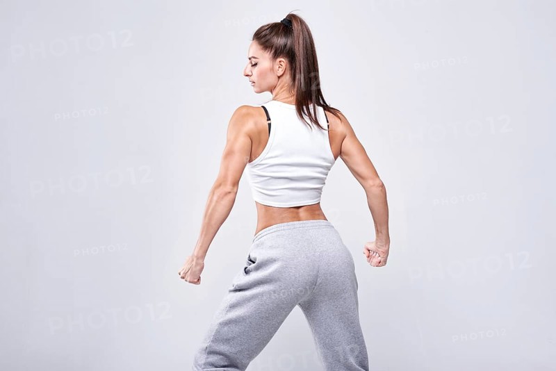 Young white fitness woman wearing sportswear standing over white wall background. Fitness concept. Mixed media