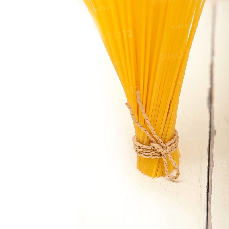 Italian pasta spaghetti tied with a rope on a rustic table
