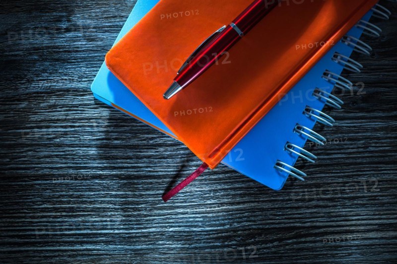 Set of notepads pen on wooden board